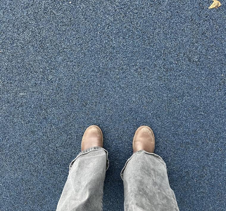 A patient's feet in supportive shoes, standing on the clinic carpet